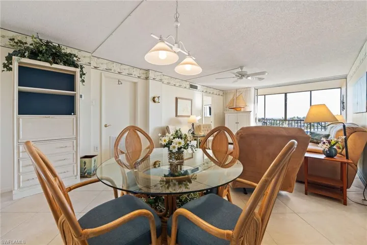 Tiled dining area featuring a textured ceiling and a ceiling fan