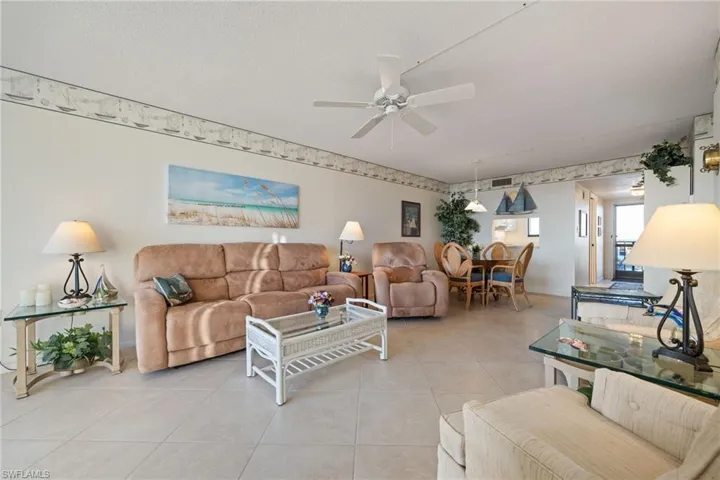 Tiled living area featuring a ceiling fan