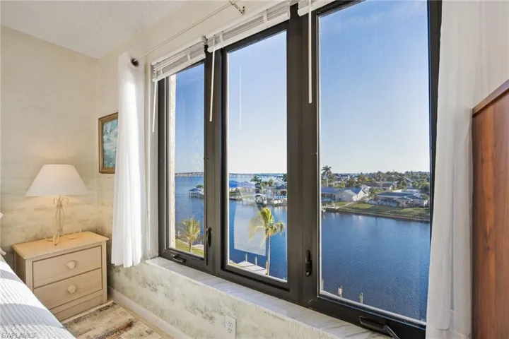 Bedroom featuring a water view and multiple windows