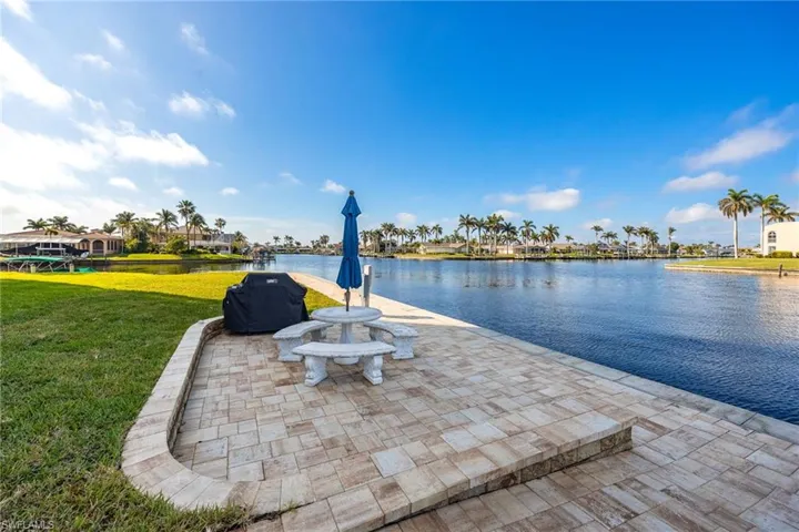 View of patio featuring a grill, a water view, and a residential view