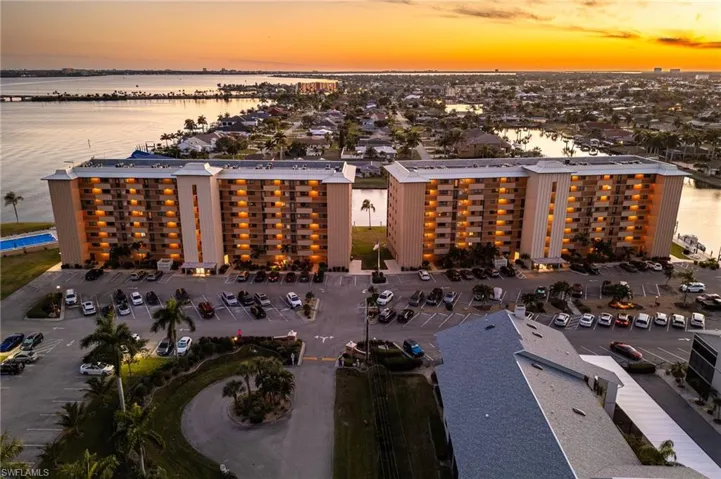 Aerial view at dusk of a view of apartment building / complex and a water view