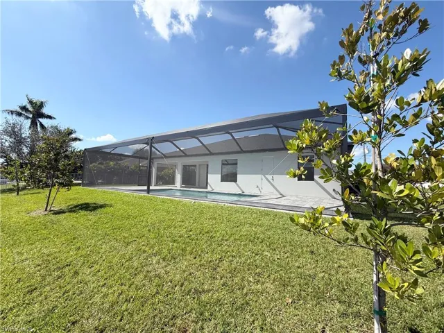 Rear view of property with a yard and a lanai