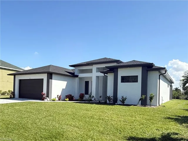 Prairie-style home with a garage and a front yard