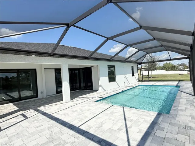 View of swimming pool with a patio and a lanai