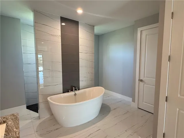 Bathroom featuring tile walls and a bathtub