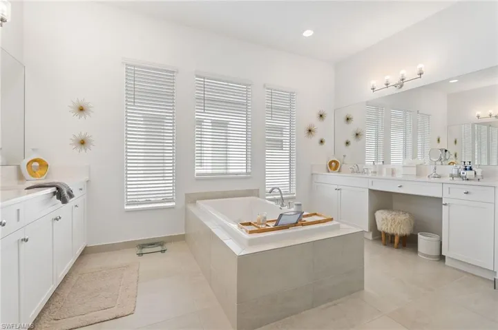 Spa-like primary bathroom with dual vanities, soaking tub.