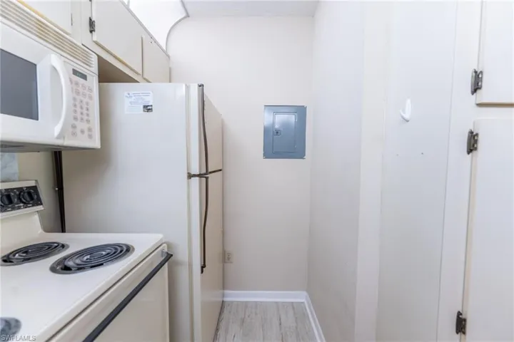 Kitchen featuring white cabinets and white appliances