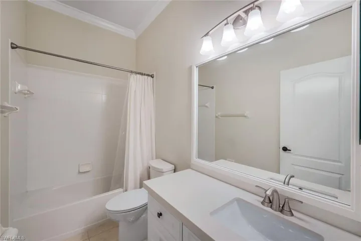 Bathroom featuring a vanity with an integrated sink, a large framed mirror, and an overhead light fixture