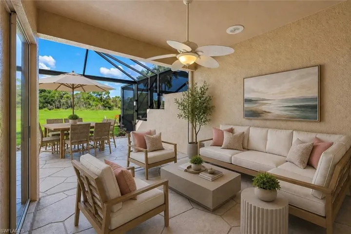 Expansive covered patio featuring flagstone flooring, a ceiling fan, and a screened enclosure