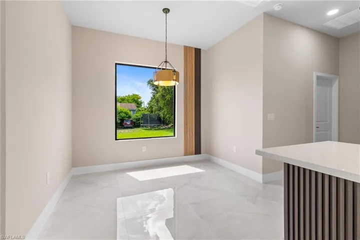 Unfurnished dining area featuring light marble finish flooring and recessed lighting