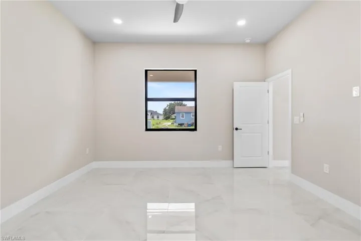Empty room featuring a ceiling fan, light marble finish flooring, and recessed lighting