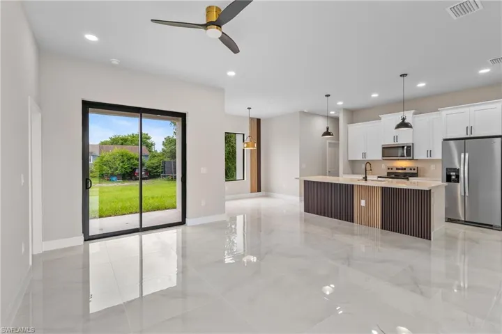 Kitchen with appliances with stainless steel finishes, white cabinets, a kitchen island with sink, recessed lighting, and ceiling fan