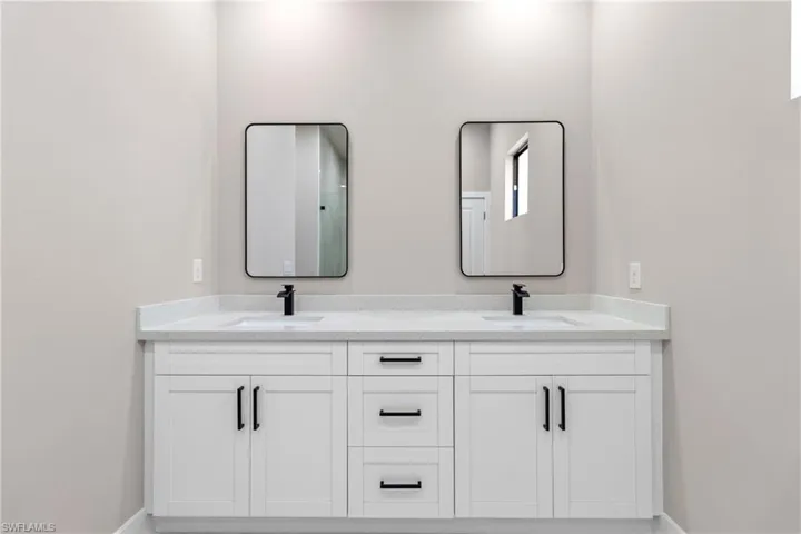 Bathroom with double vanity and baseboards