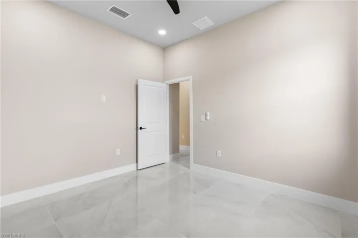 Empty room with a ceiling fan and recessed lighting
