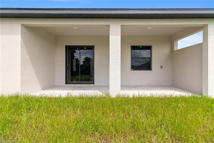 View of exterior entry featuring a patio area and stucco siding