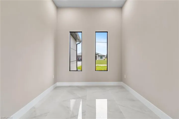 Unfurnished room featuring baseboards and light marble finish flooring