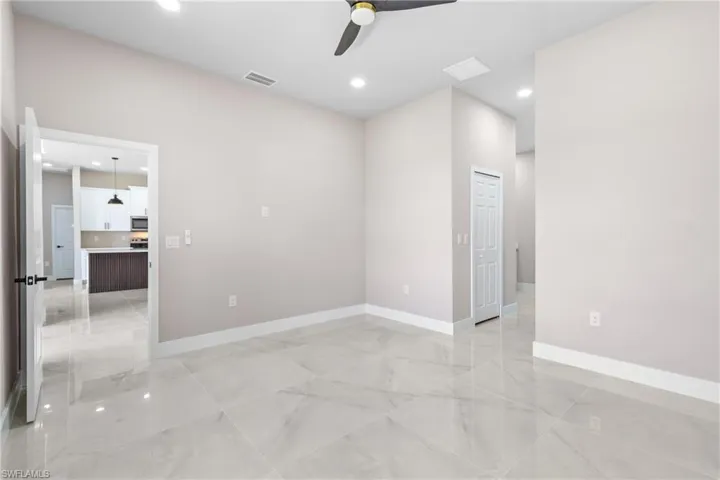 Unfurnished room featuring recessed lighting, light marble finish floors, and ceiling fan