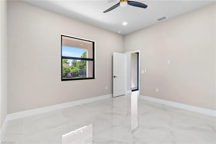 Empty room featuring light marble finish floors, recessed lighting, and ceiling fan