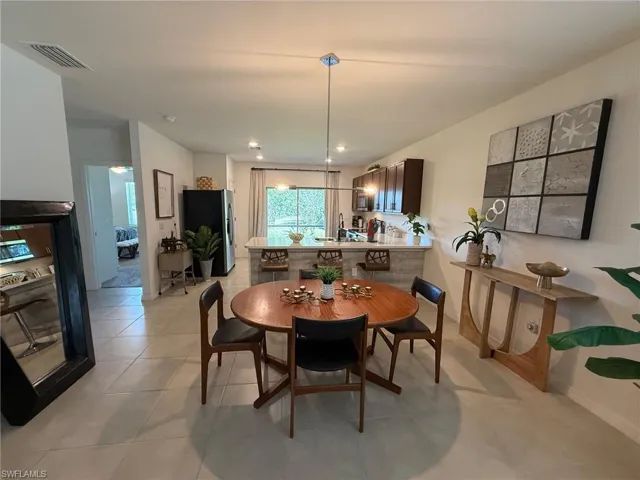 Dining room with light tile patterned floors and recessed lighting