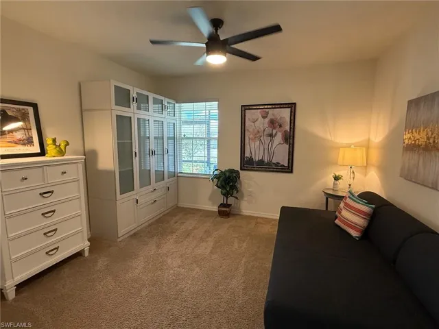 Living area with light carpet and ceiling fan