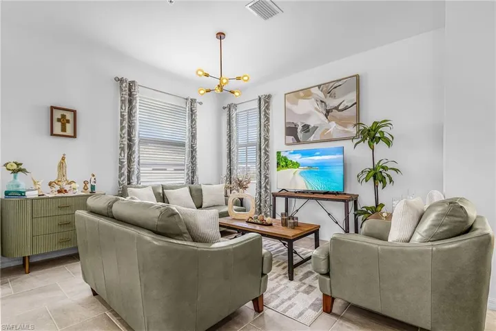 Bright living area featuring light-toned tile flooring and white walls