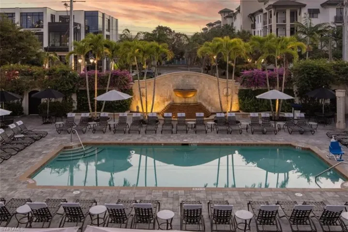 Community Pool at dusk featuring a patio area with plenty of lounge chairs