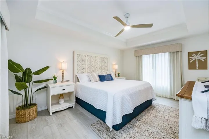 Primary Bedroom with king bed, tray ceiling and ceiling fan
