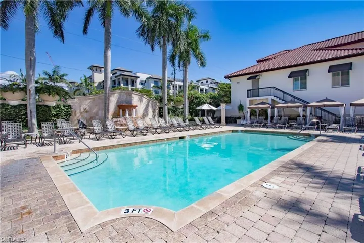 View of community pool with a patio area, lounge chairs and cabanas