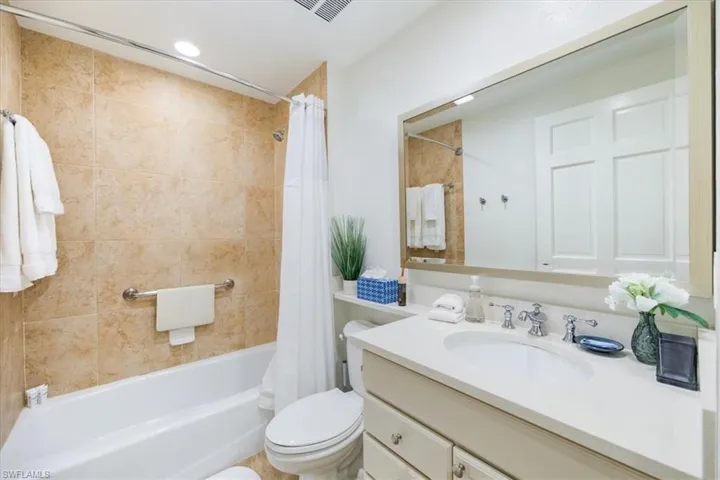 Full guest bathroom featuring vanity, toilet, and shower / tub combo