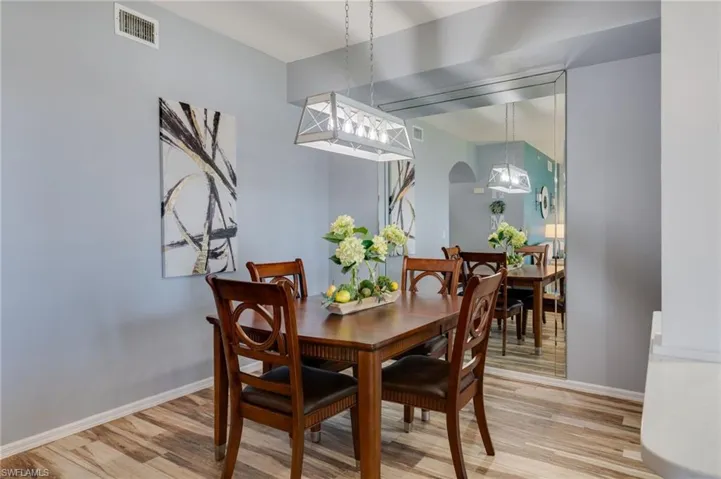 Dining area with light wood-style floors and arched walkways