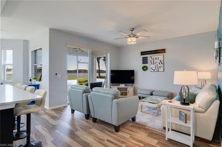 Living area with light wood finished floors and a ceiling fan