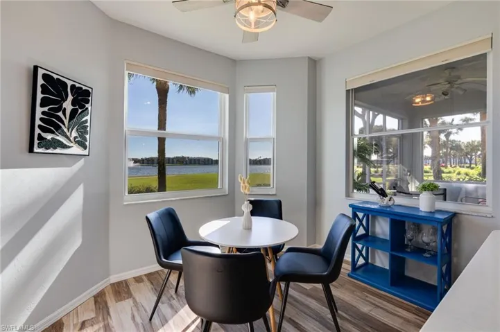 Dining room with ceiling fan, a water view, and wood finished floors