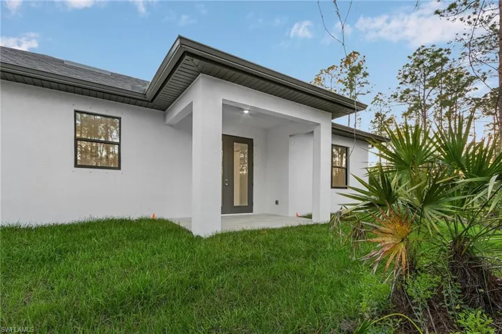 Rear view of property with a yard