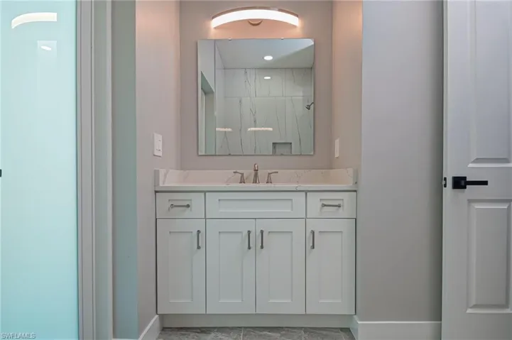 Full bath with vanity and a marble finish shower