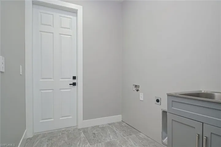 Laundry room with electric dryer hookup, cabinet space, and hookup for a washing machine