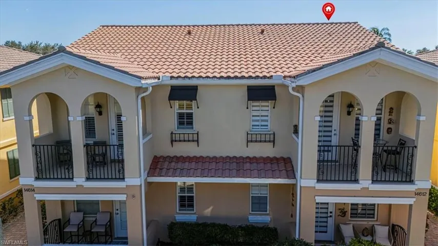 Back of property featuring a balcony, a tile roof, and stucco siding