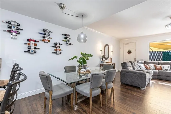 Dining space with dark wood-style floors and crown molding