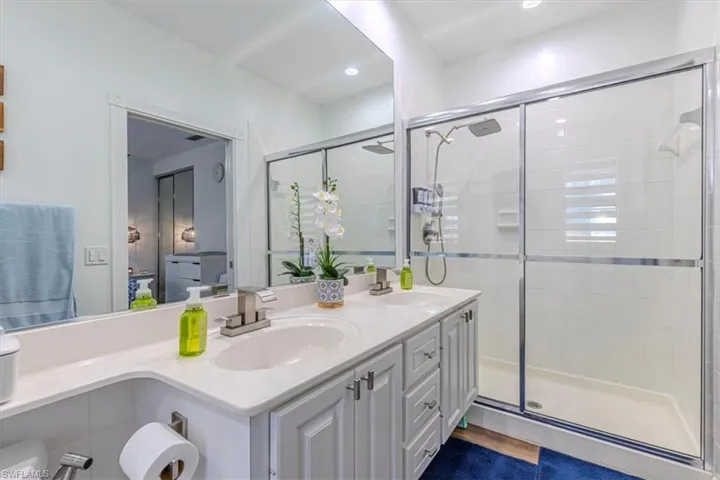 Bathroom with double vanity and a stall shower