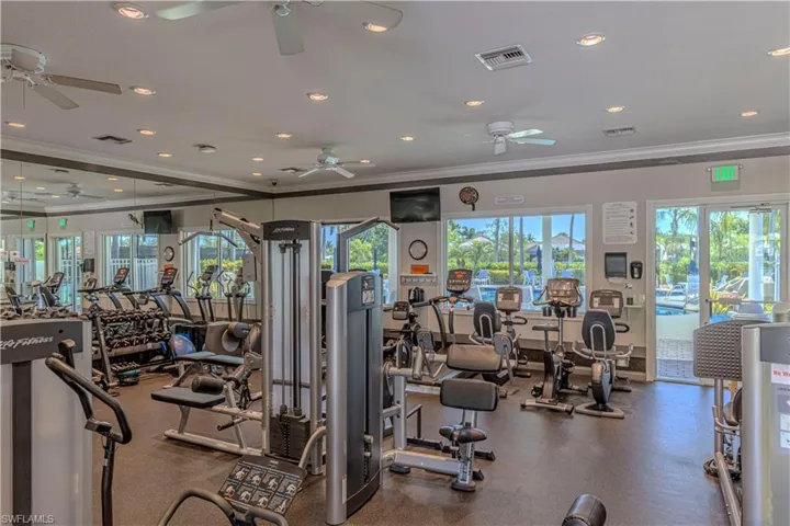 Gym with crown molding and recessed lighting