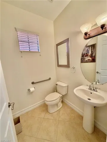 Bathroom with baseboards and light tile patterned flooring