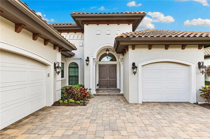 View of front of home with a garage, stucco siding, a tiled roof, and decorative driveway