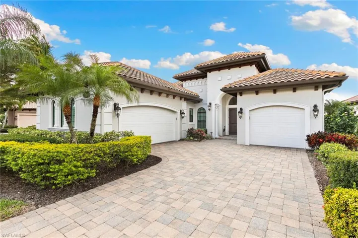 Mediterranean / spanish-style home featuring an attached garage, stucco siding, decorative driveway, and a tile roof