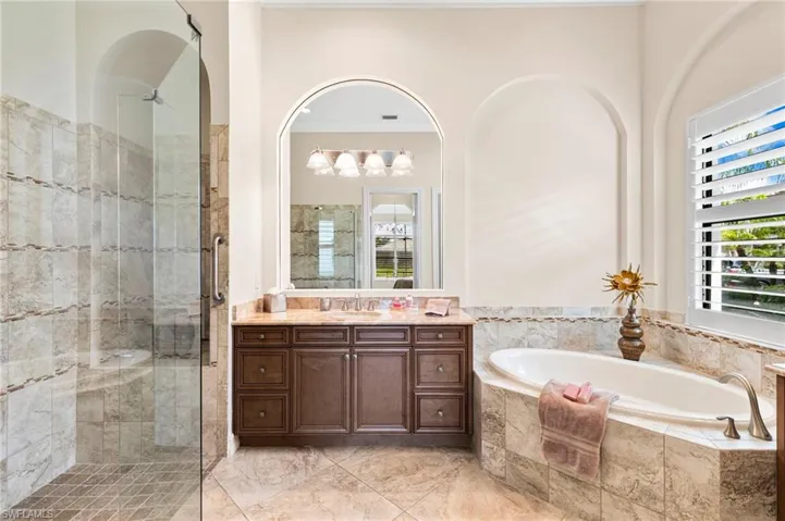Bathroom featuring a stall shower, vanity, a bath, and crown molding