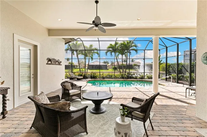 View of patio with a sunroom, glass enclosure, ceiling fan, and an outdoor pool