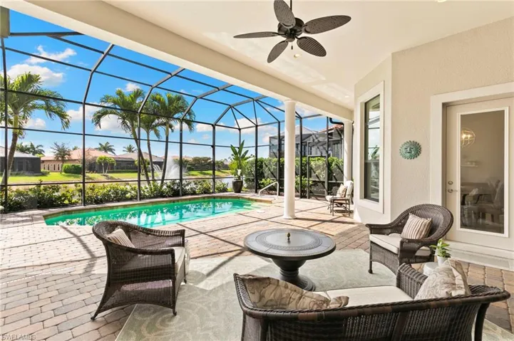 View of patio with a sunroom, glass enclosure, ceiling fan, and an outdoor pool