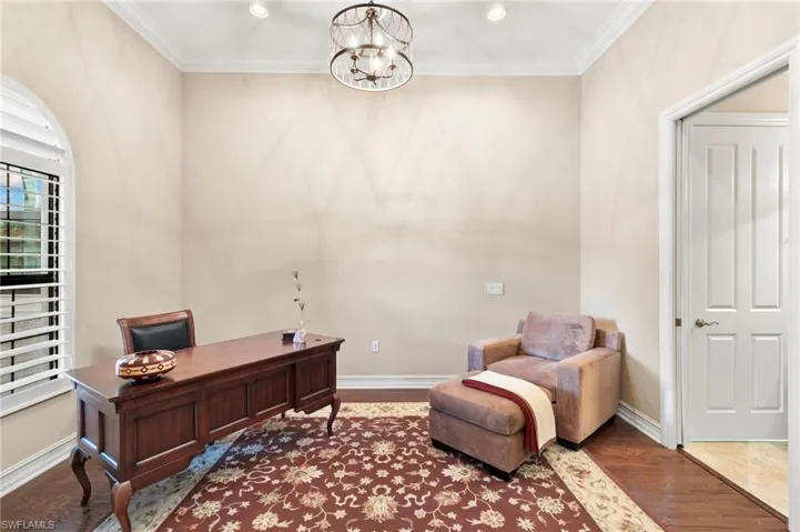 Home office featuring crown molding, a chandelier, and wood finished floors