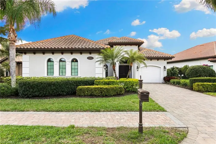 Mediterranean / spanish house with stucco siding, a garage, a tiled roof, and decorative driveway