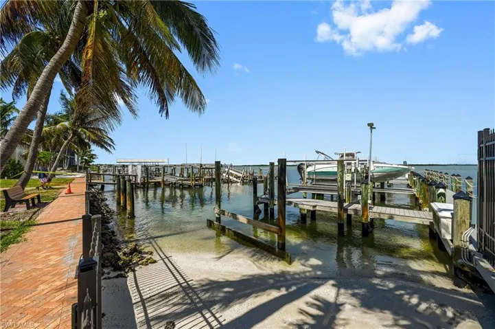 Waterfront property featuring extensive boat docks, a boat lift, and a hardscaped pathway