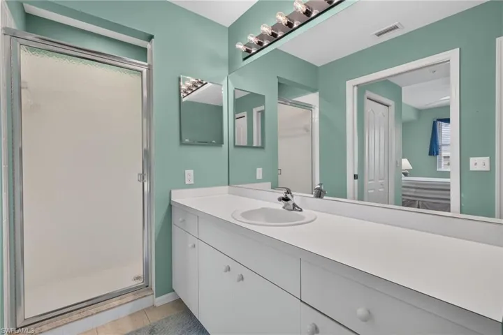 Bathroom featuring a white vanity with integrated sink, chrome faucet, and ample countertop space
