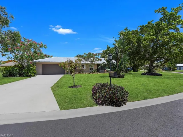 View of front of house featuring a garage and a front yard